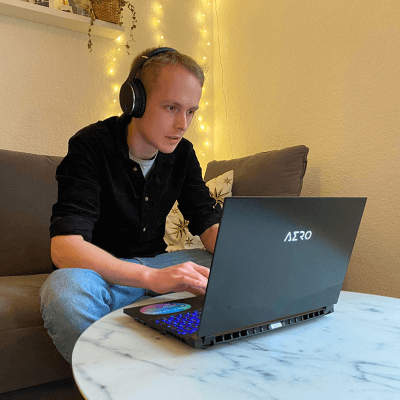 Creator mit einem Aero 15 Oled vor sich auf dem Tisch