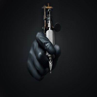 Eine Hand, die eine Tätowiermaschine hält.
