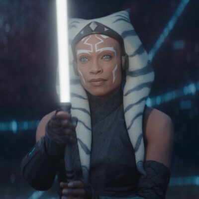 Protagonistin Ahsoka Tano aus der gleichnamigen Serie in der Dunkelheit durch ihr helles Lichtschwert erleuchtet.