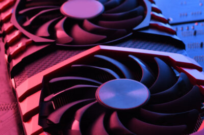 Eine Grafikkarte mit rotem und blauen Licht in Szene gesetzt. Im Hintergrund erkennt man ein Mainboard.