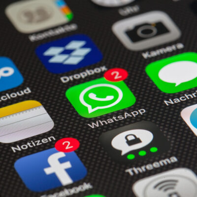 Mehrere Apps auf einem Smartphone. Im Mittelpunkt ist Whatsapp mit zwei neuen Nachrichten.